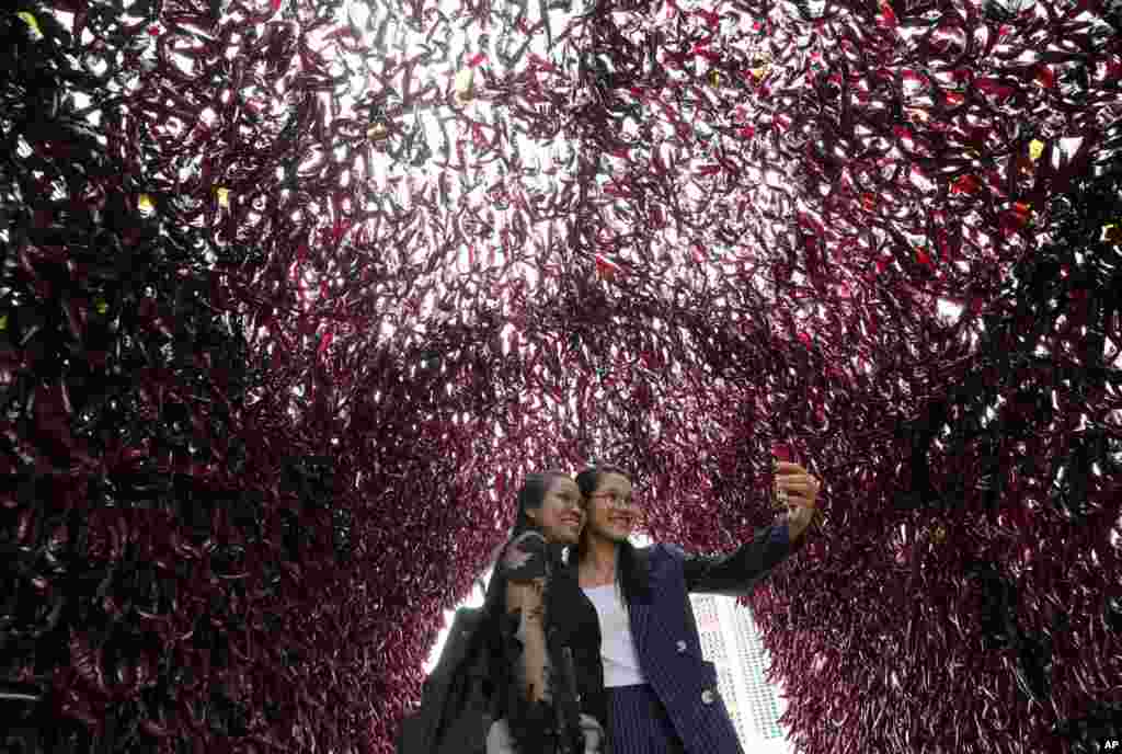 Women take a selfie inside a tunnel made with red peppers during H.O.T Festival at Seoul Plaza in Seoul, South Korea.