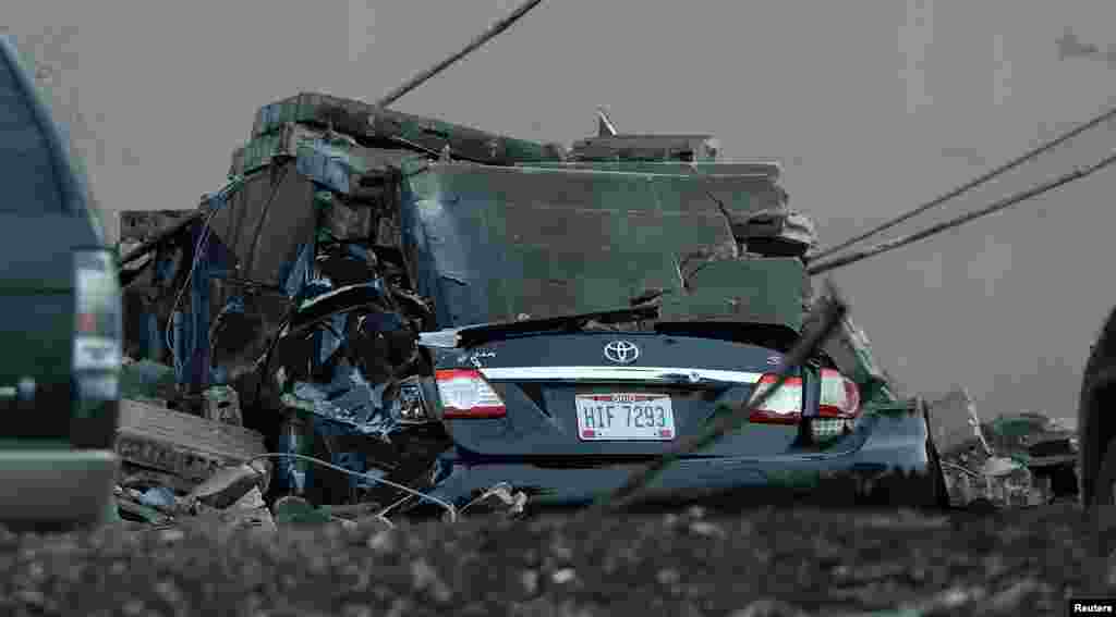 A vehicle is destroyed by a brick wall that fell from the I Schumann & Co. metals plant after an explosion at the factory in Bedford, Ohio.