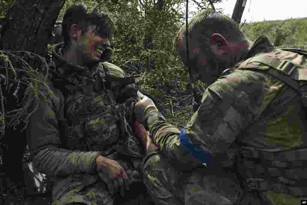 A soldier of Ukraine's 3rd Separate Assault Brigade gives first aid to his wounded comrade near Bakhmut, the site of fierce battles with the Russian forces in the Donetsk region, Sept. 4, 2023.