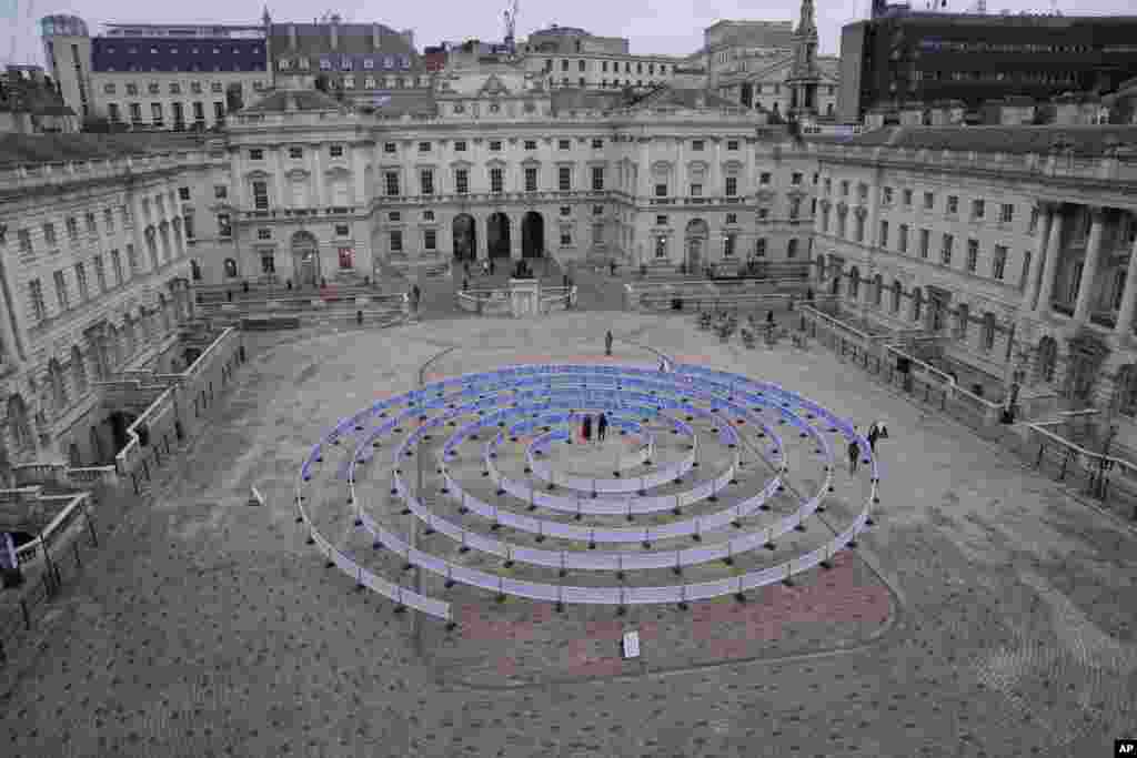 A work entitled 'Whorled (Here After Here After Here)' by Indian artist Jitish KallatIn, standing in the center, at Somerset House in London.