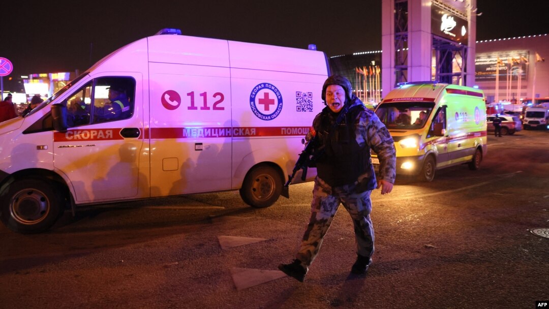Policajac viče na prolaznike i reportere ispred hale Krokus siti u predgrađu Moskve, gde se dogodio napad (Foto: AFP)