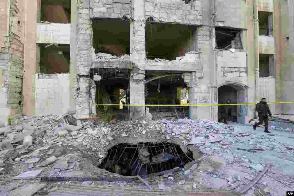 Members of security forces inspect a building damaged in a reported Israeli missile strike in Damascus, Syria. An Israeli missile strike aimed at Iranian and Hezbollah targets killed 15 people and destroyed a building in a Damascus neighborhood home to much of Syria's security apparatus, a war monitor said. 