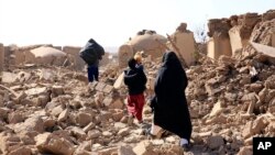 Avganistanke hodaju sa decom kroz ruševine nakon snažnih zemljotresa u pokrajini Herat, zapadno od Avganistana, 15. oktobra 2023.