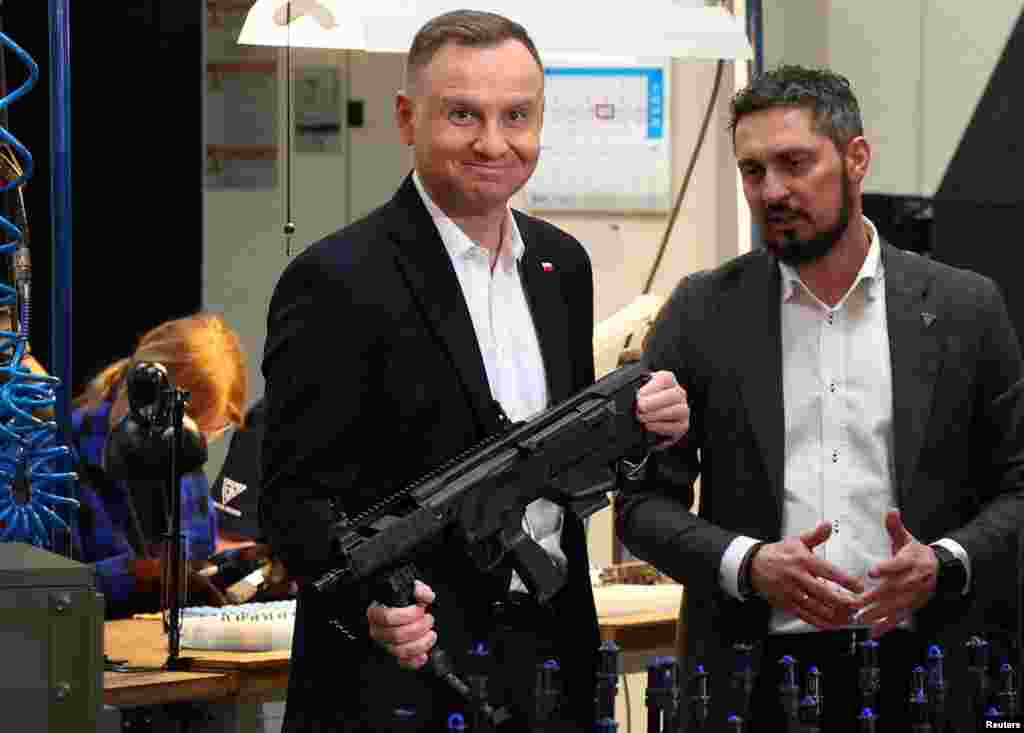 Polish President Andrzej Duda holds a GROT, a modular assault rifle system, at the arms factory Fabryka Broni Lucznik in Radom, Poland.