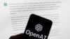 FILE - The OpenAI logo is seen on a mobile phone in front of a computer screen displaying output from ChatGPT, March 21, 2023, in Boston.