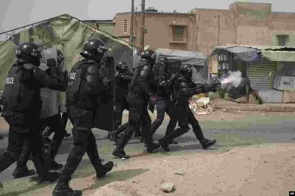 A riot police officer fires tear gas at supporters of the opposition leader's Ousmane Sonko after he left the tribunal in Dakar, Senegal.