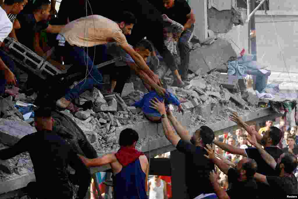 Palestinians carry a child at the site of an Israeli strike on a house, in Khan Younis, in the southern Gaza Strip.