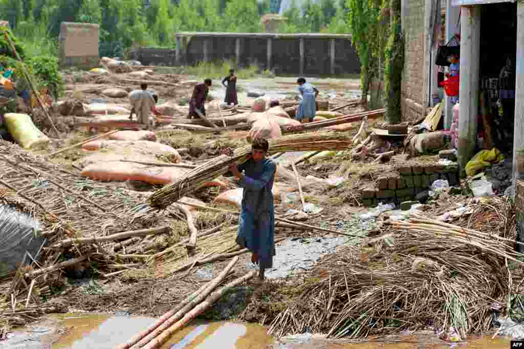 Afghan villagers clean debris after flash floods in Mohmand Dara district of Nangarhar province.