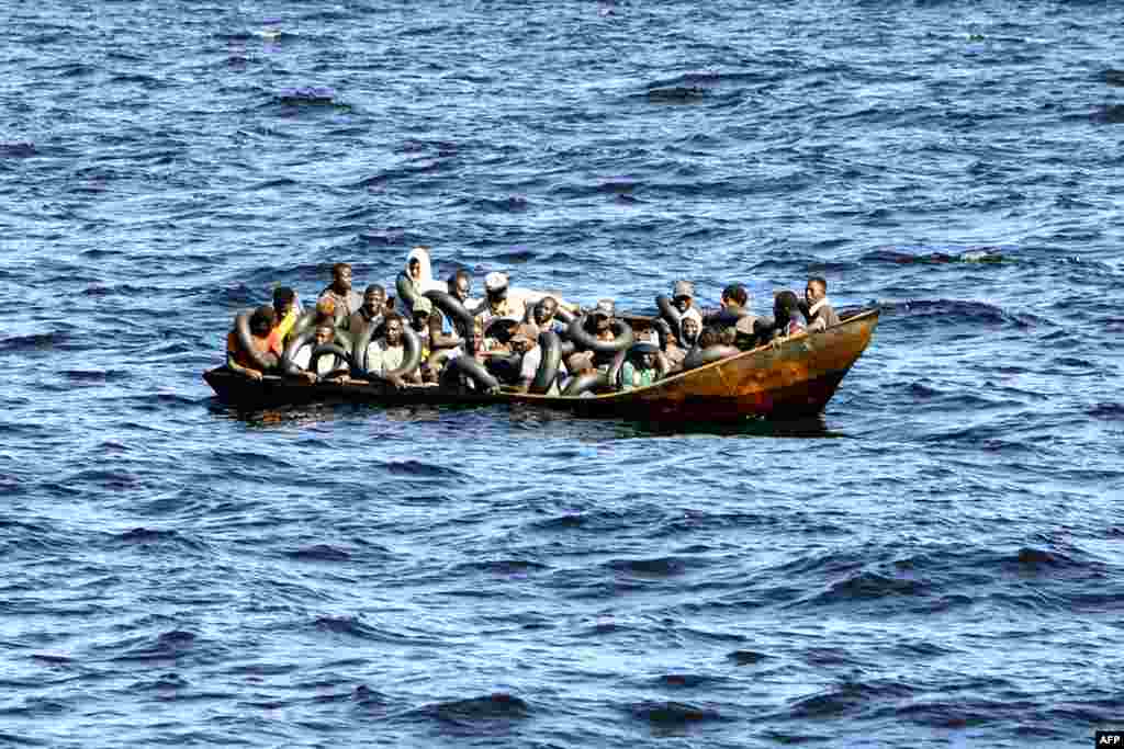Migrants of African origin are crammed on board a small boat as the Tunisian coast guard prepares to transfer them onto their vessel while at sea, between Tunisia and Italy.