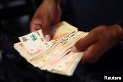 Un vendedor ambulante de comida cuenta dinero en Buenos Aires, Argentina, 12 de diciembre de 2023.