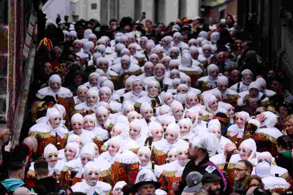 Revelers dressed as a "Gilles", the oldest and principal participants in the Carnival of Binche in Belgium, take part in the parade in Binche, Belgium.