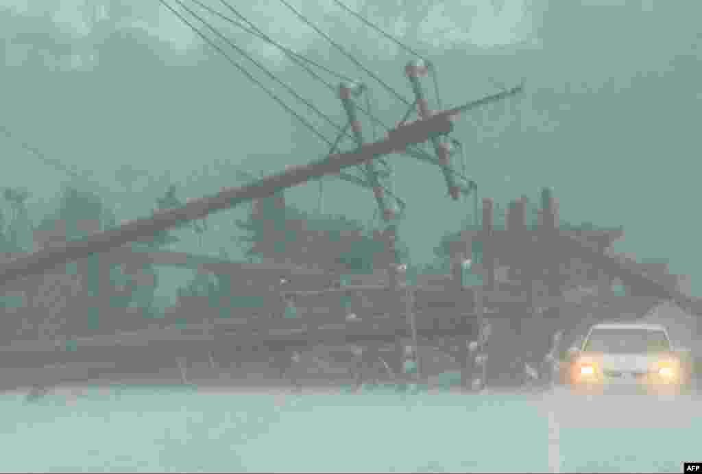 A car drives past power lines downed by the high winds from Typhoon Koinu in Taiwan's southern Pingtung County, Taiwan.