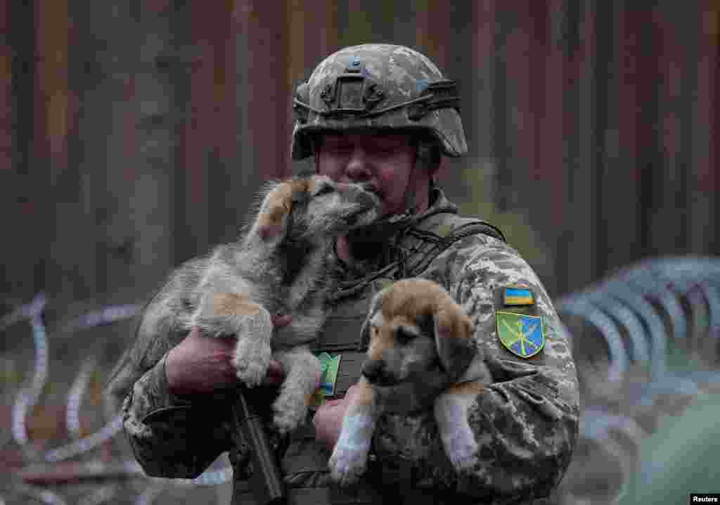 Commander of the Joint Forces of the Armed Forces of Ukraine Serhiy Nayev holds puppies as he visits at positions near the border with Belarus in Zhytomyr region, Ukraine, Sept. 20, 2023.