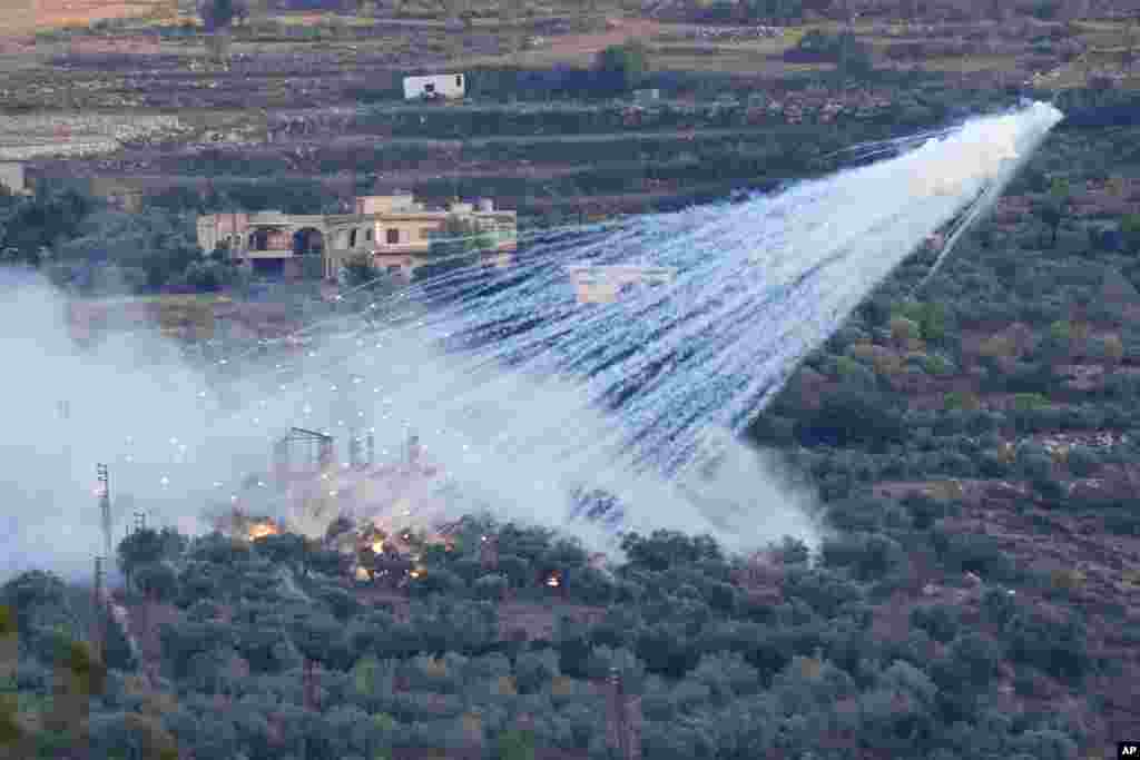 A shell from Israeli artillery explodes over a house in al-Bustan, a Lebanese border village with Israel, south Lebanon. Hamas Palestinian militants in southern Lebanon fired 20 rockets into the northern Israeli towns of Schlomi and Nahariyya, the group said in a statement.