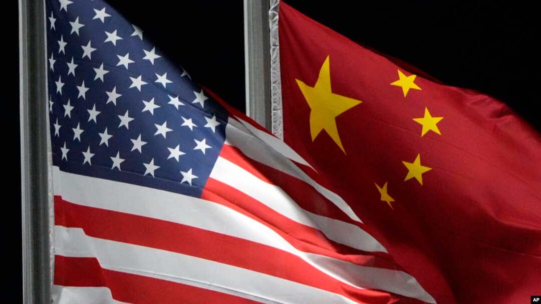 FILE - The American and Chinese flags wave at Genting Snow Park ahead of the 2022 Winter Olympics, Feb. 2, 2022, in Zhangjiakou, China. U.S. national security adviser Jake Sullivan is heading to China next week for talks with Chinese Foreign Minister Wang Yi.