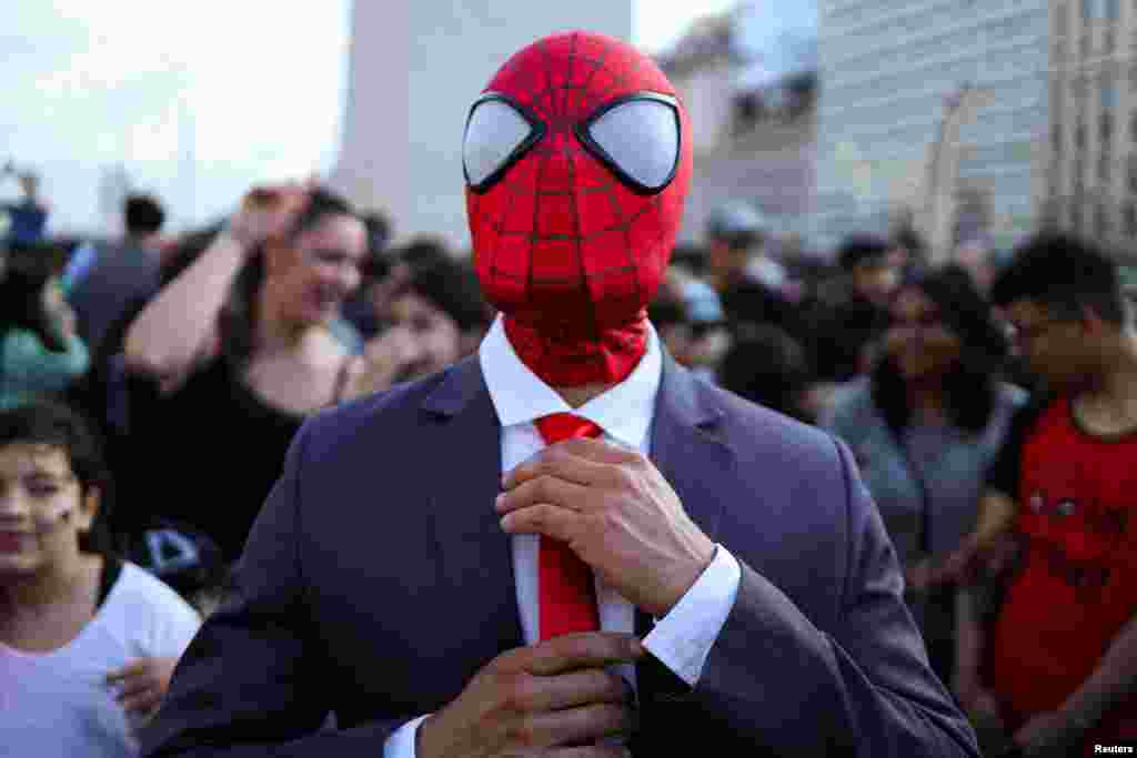A man dressed as Spider-Man adjusts his tie at a Spider-Man cosplayers' gathering, organised in an attempt to set a Guinness World Record for the largest gathering of people dressed as Spider-Man, in Buenos Aires, Argentina, Oct. 29, 2023.