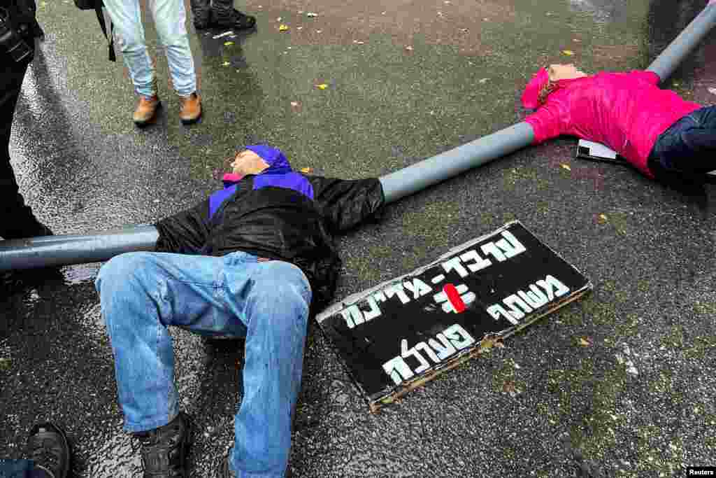 Protesters link themselves with chains and pipes to block the road leading to Israeli Prime Minister Benjamin Netanyahu's office, as his nationalist coalition government presses on with its contentious judicial overhaul, in Jerusalem.