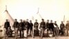 Artillery soldiers pose with Hotchkiss machine guns used against Lakota men, women and children in the 1890 Wounded Knee Massacre. 