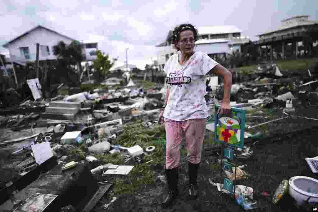 Jewell Baggett stands beside a Christmas decoration she recovered from the wreckage of her mother’s home in Horseshoe Beach, Florida, after the passage of Hurricane Idalia, Aug. 30, 2023.