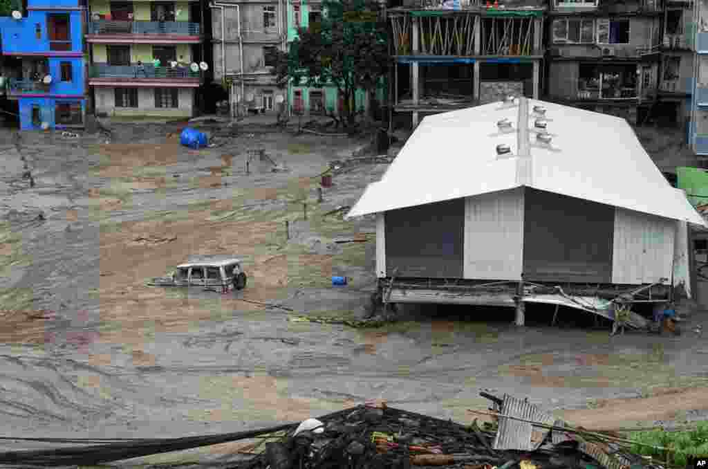 A vehicle is seen partially submerged in water after flash floods triggered by a sudden heavy rainfall swamped the Rangpo town in Sikkim, India.