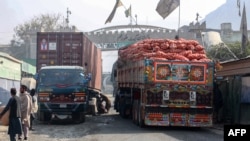 Truk yang membawa barang melewati titik nol perbatasan Torkham antara Afghanistan dan Pakistan, di provinsi Nangarhar, setelah pintu penyeberangan perdagangan utama tersebut dibuka kembali 23 Januari 2024. (Syafiullah KAKAR/AFP)