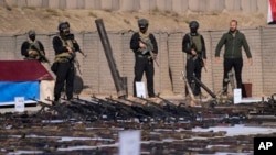 Pasukan Mobilisasi Populaer atau PMF memamerkan senjata-senjata yang disita dari para kombatan ISIS di Provinsi Salahuddin, Irak, 12 Januari 2023. (Foto: Hadi Mizban/AP Photo)