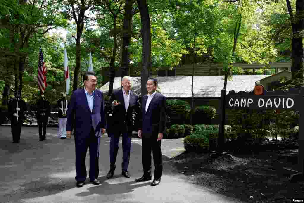 U.S. President Joe Biden, center, greets Japanese Prime Minister Fumio Kishida, right, and South Korean President Yoon Suk Yeol during the trilateral summit at Camp David near Thurmont, Md.