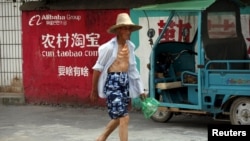中國浙江桐廬一位農民走過淘寶的廣告牆。 （2015年7月20日）