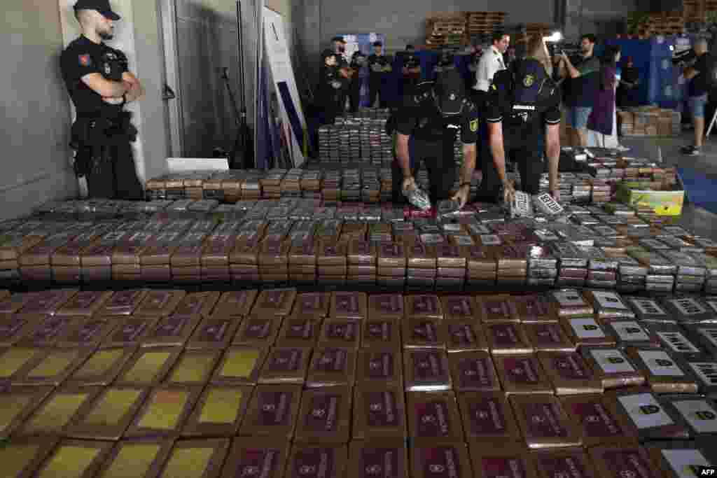 Spanish National Police and Customs officers hold packages of cocaine, which totaled 9,436 kilos, that were found hidden in a container from Ecuador, during a police press conference at the port of Algeciras, Spain. The seizure marks "the biggest cargo of cocaine in Spain to date," according to a joint statement. 