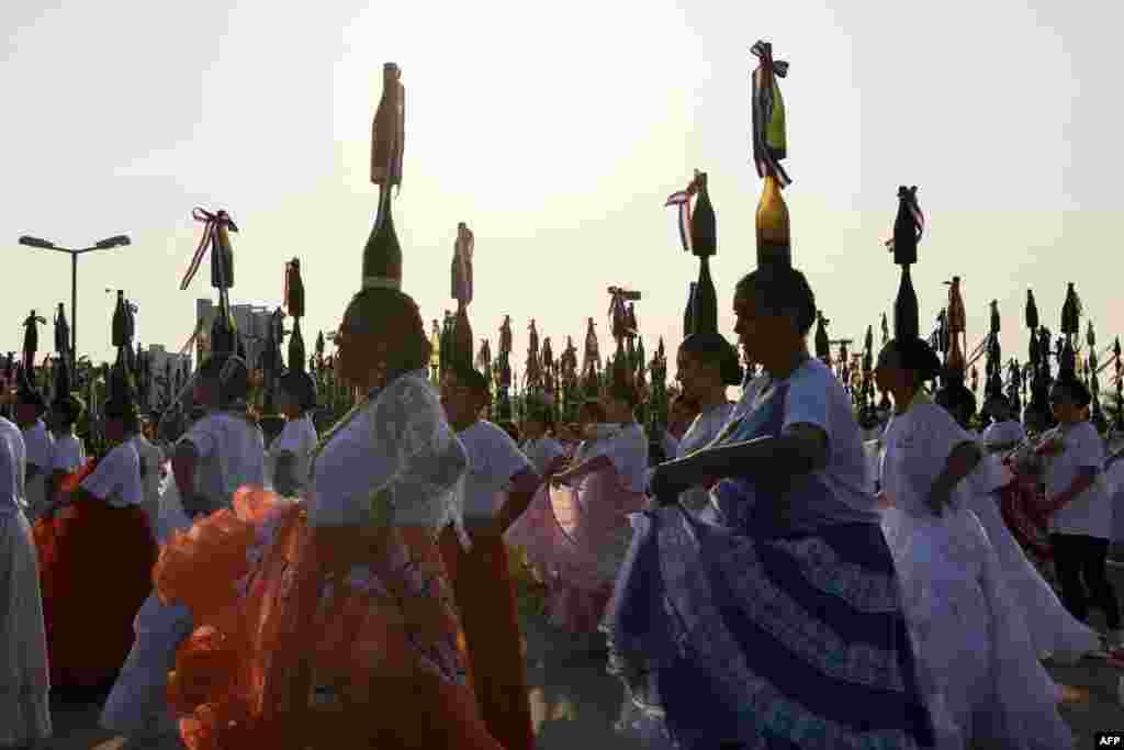 Bottle dancers attempt to set a record at the Official World Record Association on the first edition of the National Day of the Bottle Women at the Bicentennial Park in Asuncion, Paraguay, Sept. 17, 2023. Paraguay obtained an Official World Record when 580 dancers balanced 2200 bottles on their heads.