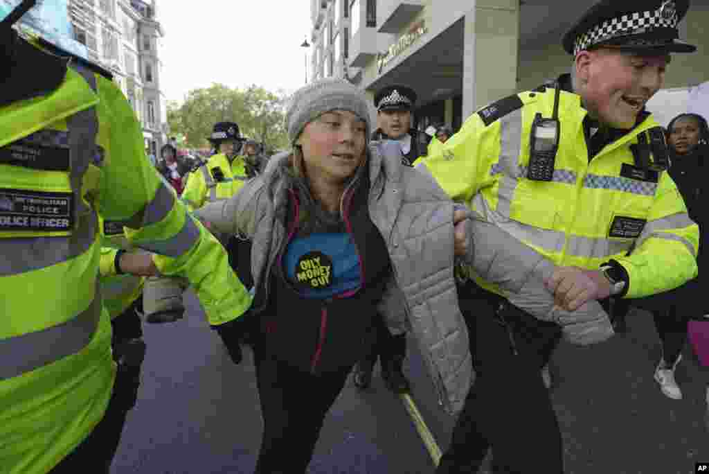 Environmental activist Greta Thunberg is taken away by police officers during the Oily Money Out protest outside the Intercontinental Hostel, in London.