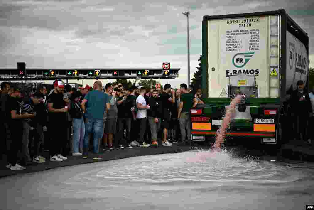 Winegrowers unload wine from a truck during a road blocking demonstration to protest against imports of Spanish wine, on the motorway at the toll booth of Le Boulou, close to the Spanish border, southern France.