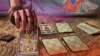En esta imagen una cartomántica lanza unas cartas. [Ilustración, VOA].