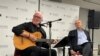 Luis Enrique Mejía Godoy conversa con el periodista Carlos Fernando Chamorro sobre sus canciones, que durante décadas han contado historias de resistencia. En un evento del Diálogo Interamericano en Washington el 14 de noviembre de 2023.