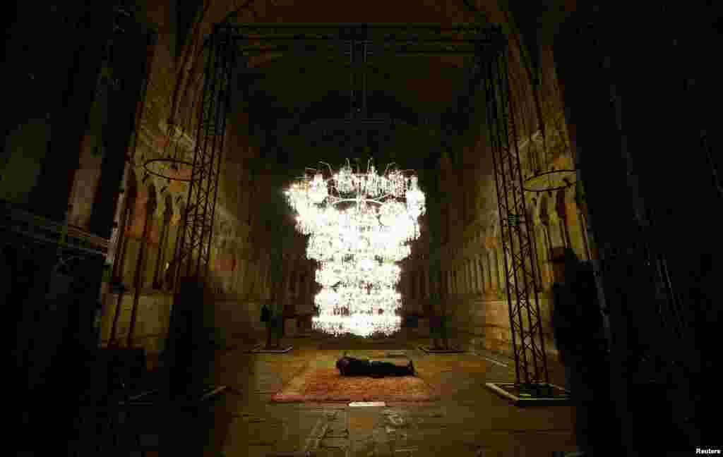 A photographer takes pictures of Chinese artist Al Weiwel’s Illuminated Bottle Rack displayed in the Chapter House room of Durham Cathedral during the biennial Lumiere photocall in Durham, Britain, Nov. 15, 2023.