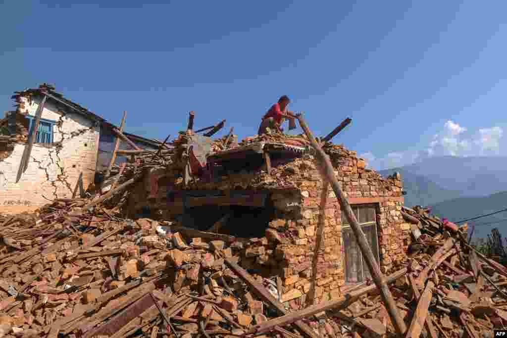 A survivor searches for belongings through the ruins of her house following an earthquake in Khalanga of Jajarkot district, Nepal. At least 157 people were killed in isolated western districts of the Himalayan country when the 5.6-magnitude earthquake hit late November 3. 