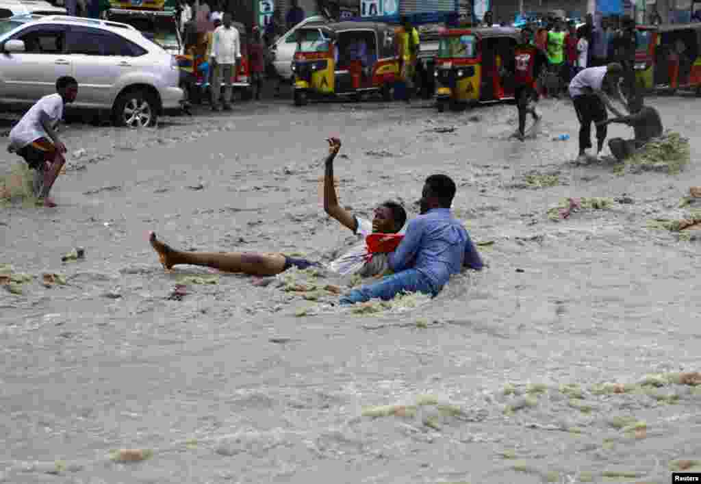 A man attempts to rescue a boy from raging flood waters following heavy rains in Mogadishu, Somalia.