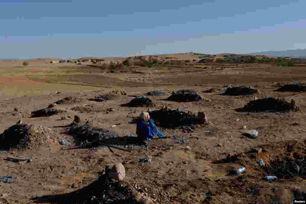 An Afghan girl cries over her mother's grave in a cemetery for victims of the recent earthquake in the district of Zinda Jan, in Herat, Afghanistan, Oct. 9, 2023.