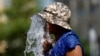 Seorang pria tampak membasahi dirinya di air mancur di salah satu lokasi di Brussels, Belgia, saat gelombang panas melanda Eropa pada 19 Juli 2022. (Foto: Reuters/Yves Herman)