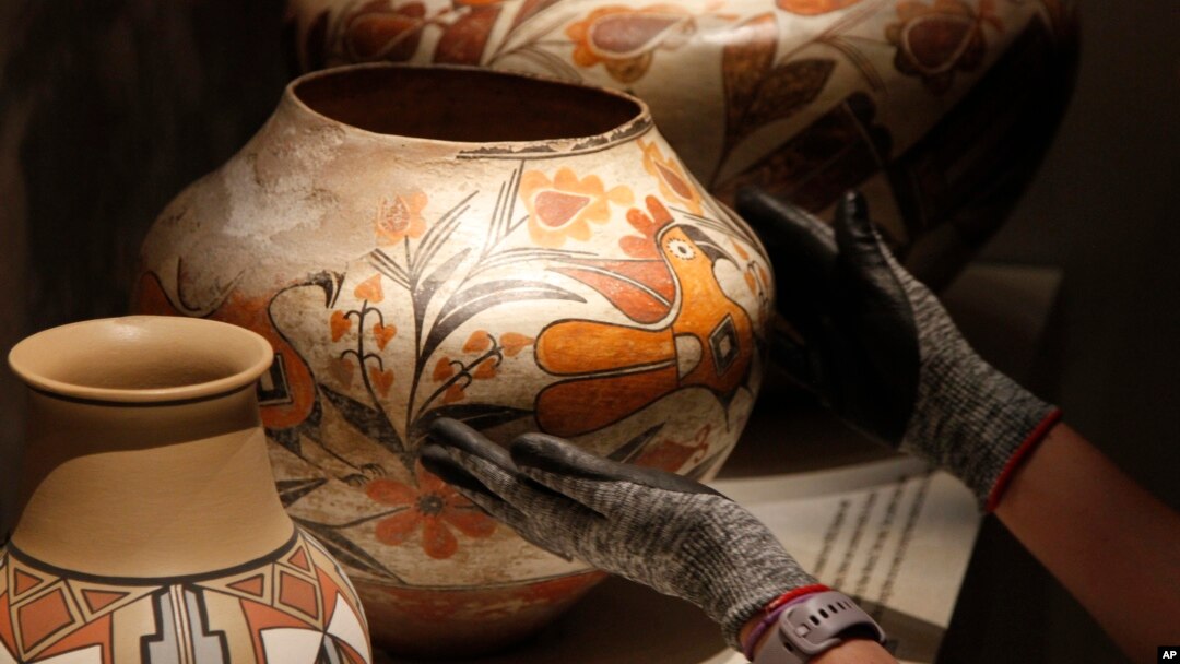 Finishing touches are made on a community-curated exhibition of Native American pottery from the Pueblo Indian region of the U.S. Southwest on July 28, 2022, at the Museum of Indian Arts and Culture in Santa Fe, N.M. (AP Photo/Morgan Lee)