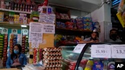 Carteles con los precios de los productos en bolívares se exhiben en una pequeña tienda en Caracas, Venezuela, el jueves 12 de mayo de 2022.