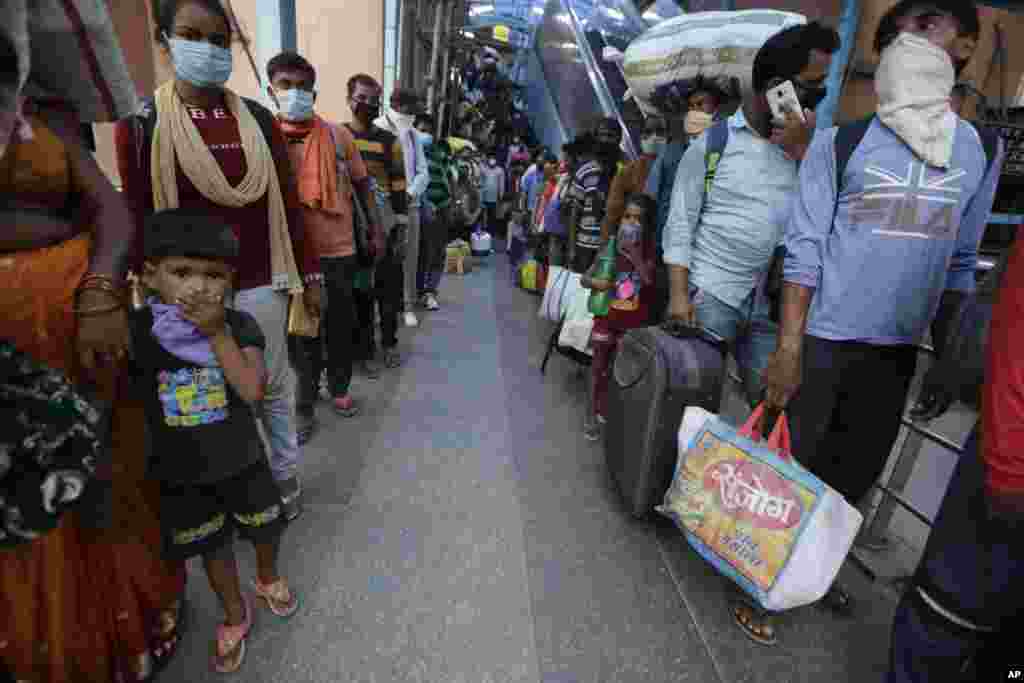 Indian passengers queue up to test for COVID-19 at a facility erected at a railway station to screen people coming from outside the city, in Ahmedabad, India.