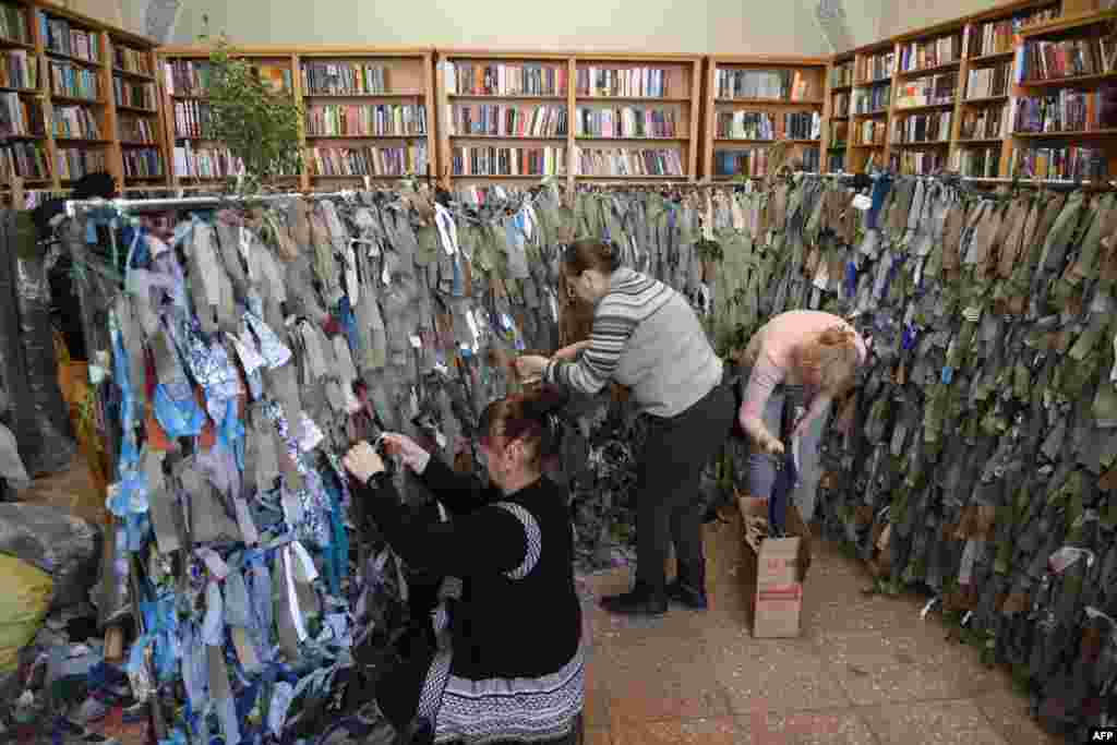 داوطلبان در یک کتابخانه در شهر لویو در غرب اوکراین برای ارتش اوکراین تورهای استتار درست می کنند. (۱۰ اسفند ۱۴۰۰)