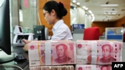 在中國江蘇省南通市的一家銀行，一名員工處理100元紙幣。 （2018年7月23日）
