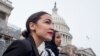 FILE - Rep. Alexandria Ocasio-Cortez, left, and D-N.Y., Rep. Ilhan Omar, D-Minn., center, walk down the House steps to take a group photograph of the House Democratic women members of the 116th Congress on the East Front Capitol Plaza on Capitol Hill.