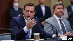 Republican Congressman Mike Gallagher, left, speaks at the Capitol, in Washington, Aug. 30, 2021. Gallagher is leading a new House Select Committee on China. 