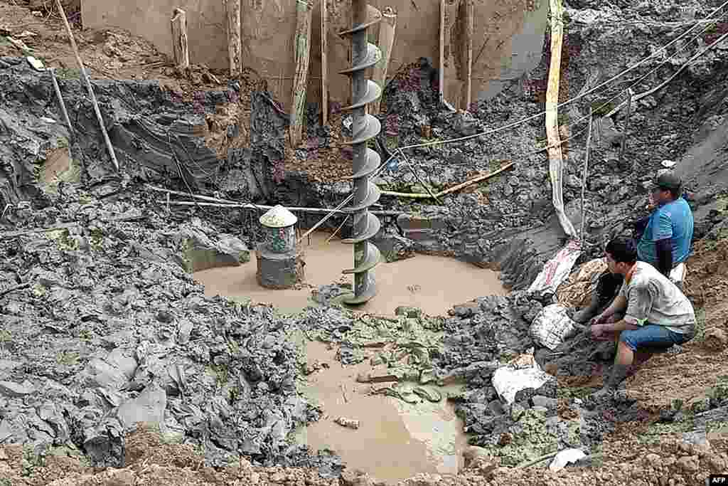 Rescuers gather at the site of where a 10-year-old boy is thought to be trapped in a 35-meter deep shaft at a bridge construction area in Vietnam's Dong Thap province.