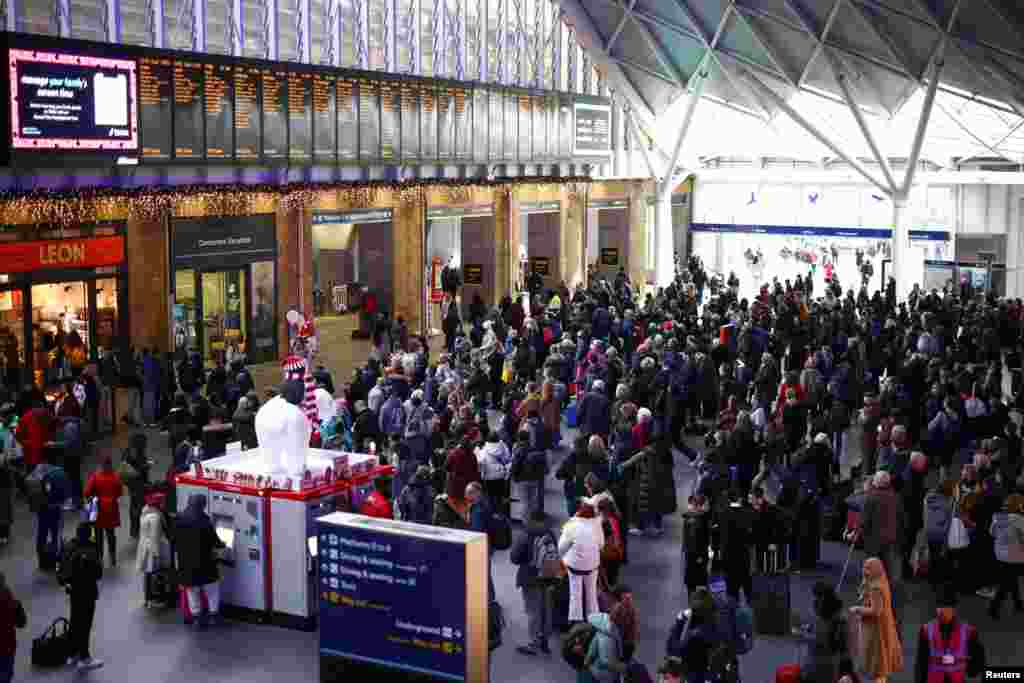 People look at screens displaying train times at Kings Cross Station, after members of the RMT Union working for Network Rail ended their strike, in London.