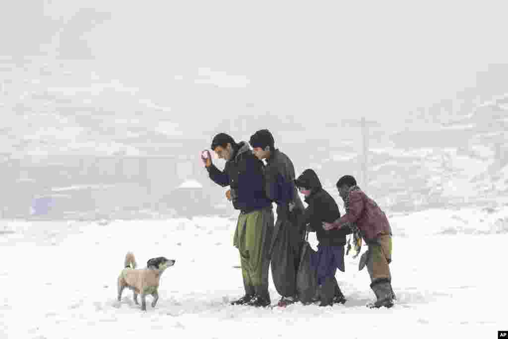Afghan boys enjoy their time playing in a snowy day on the outskirts of Kabul, Afghanistan, Jan. 11, 2023.