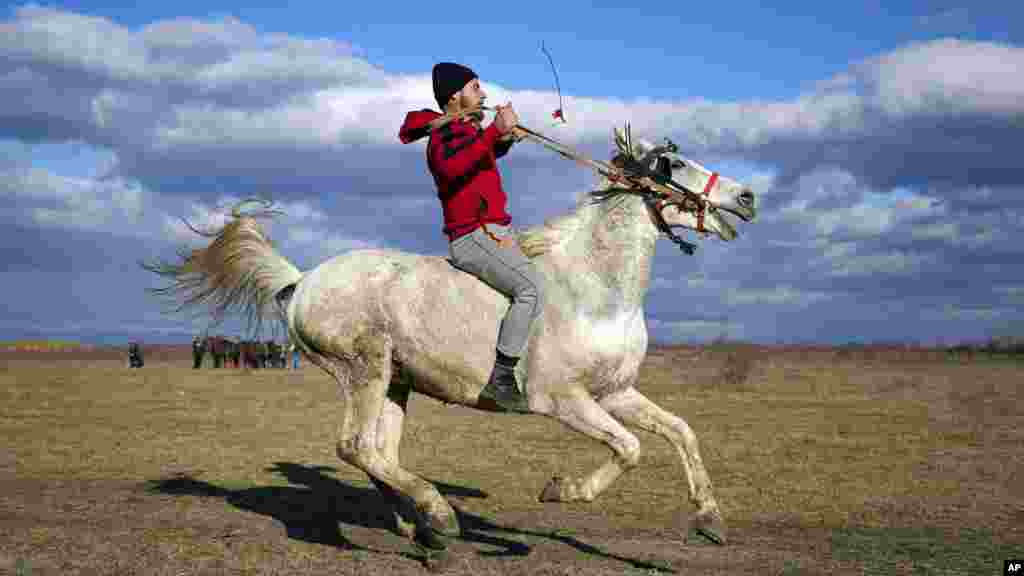 A man rides a horse during Epiphany celebrations in the village of Pietrosani, Romania.